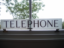 Glass Telephone sign - half cleaned