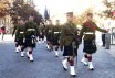 Crown Copyright; A party from the serving Liverpool Scottish element of the King's and Cheshire Regiment march towards the Menin Gate followed by the standard of the Liveropool Scottish Regimental Association and the Old Comrades
